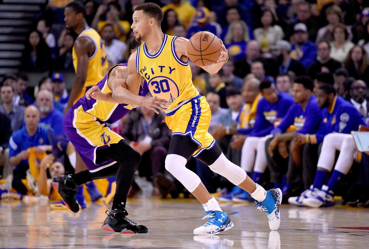 Golden State guard Stephen Curry dribbles past Lakers guard Jordan Clarkson during a game on Nov. 24.