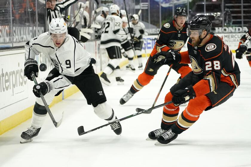 Los Angeles Kings right wing Adrian Kempe, left, skates against Anaheim Ducks defenseman Jani Hakanpaa during the third period of an NHL hockey game Monday, March 8, 2021, in Anaheim, Calif. The Ducks won 6-5 in overtime. (AP Photo/Mark J. Terrill)