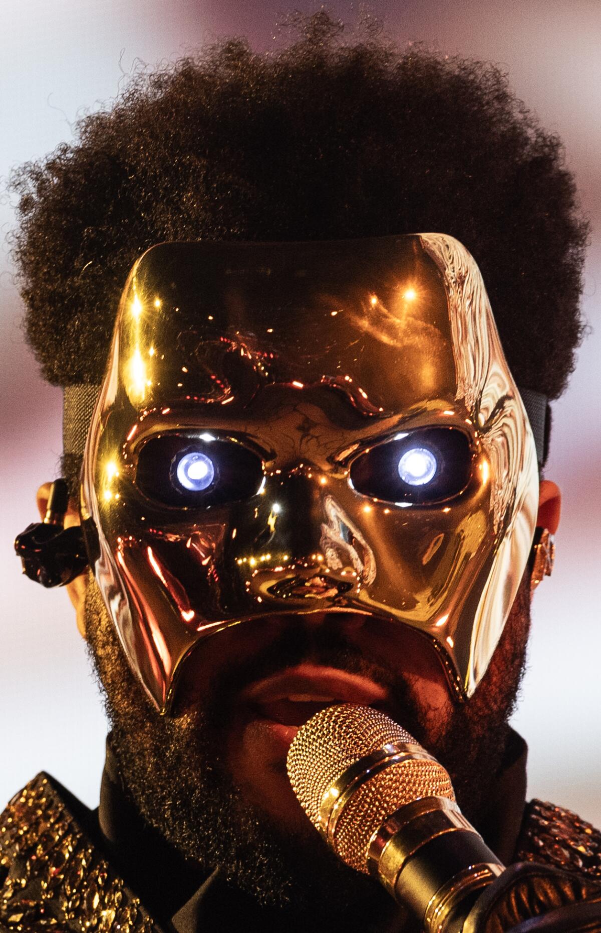 Homem em uma máscara de ouro com olhos brilhantes