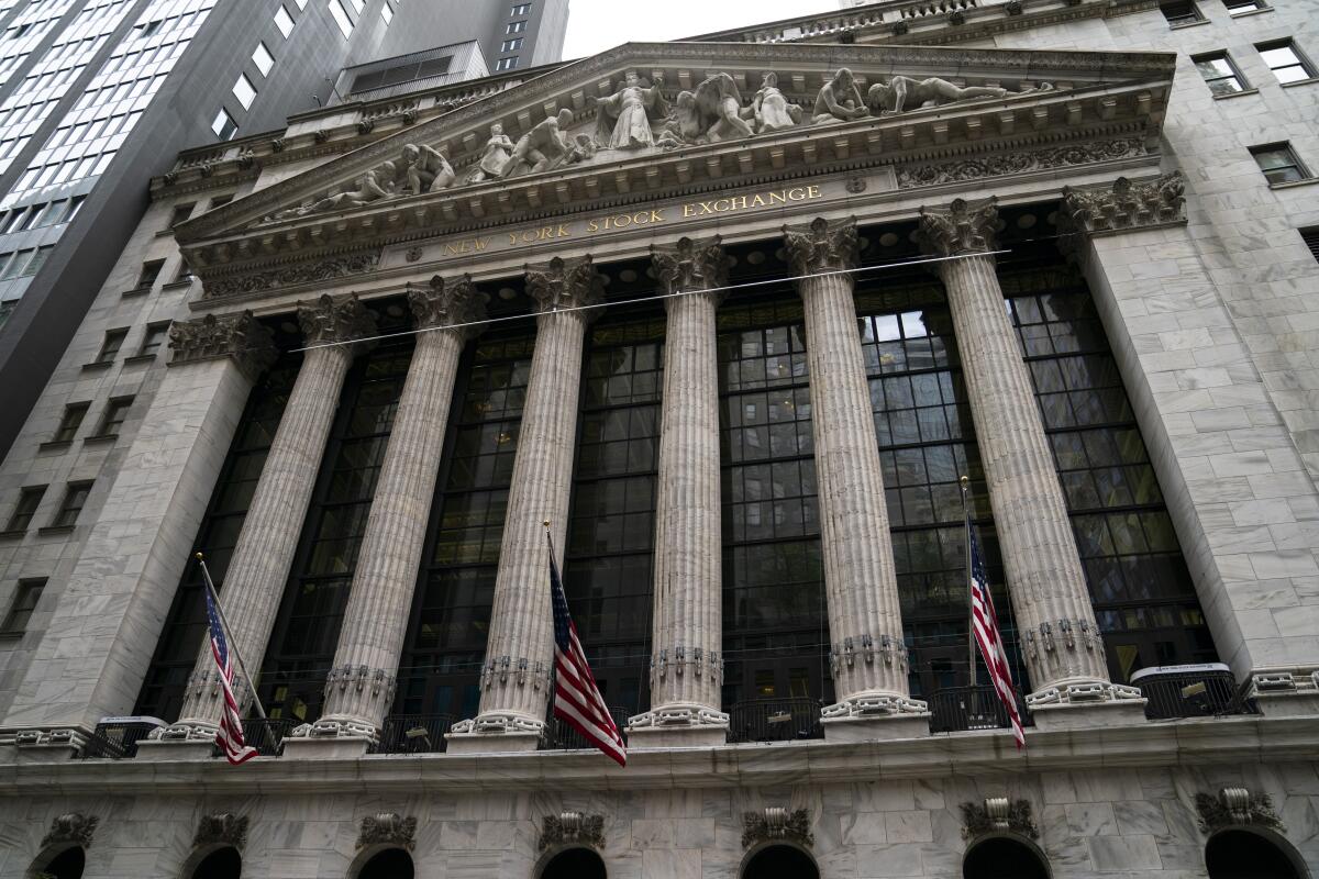 Three American flags are in front of the New York Stock Exchange. 