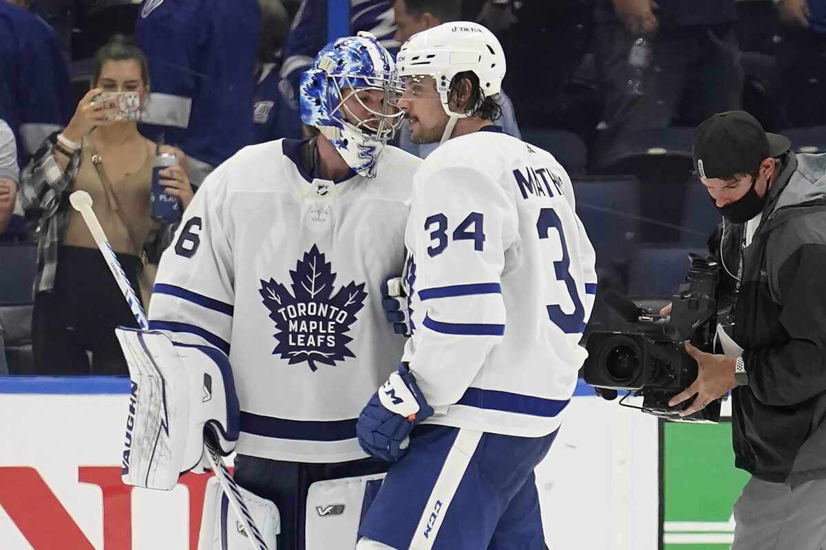 Toronto Maple Leafs goaltender Jack Campbell (36) and center Auston Matthews (34) celebrate after the team defeated the Tampa Bay Lightning during Game 3 of an NHL hockey first-round playoff series Friday, May 6, 2022, in Tampa, Fla. (AP Photo/Chris O'Meara)