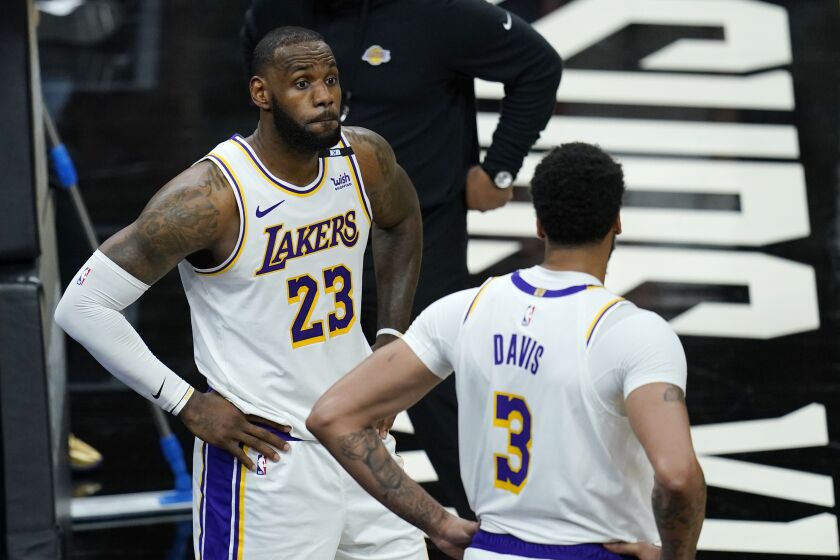 Los Angeles Lakers forwards LeBron James (23) and Anthony Davis (3) pause on the court.