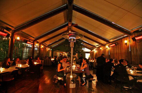 One of Eveleigh's dining rooms has a canvas roof and a communal table in the middle and open-air sides.