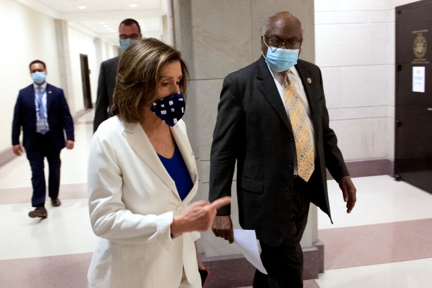 US Speaker of the House Nancy Pelosi wearing a mask to protect herself and others from COVID-19, known as coronavirus, arrives alongside US House Majority Whip Representative James Clyburn, Democrat of South Carolina, for her weekly press conference on Capitol Hill in Washington, DC, April 30, 2020. - The US Federal Reserve said April 30, 2020 it is expanding its business loan program to reach more firms as companies struggle to weather the impact of the coronavirus shutdowns. (Photo by SAUL LOEB / AFP) (Photo by SAUL LOEB/AFP via Getty Images)