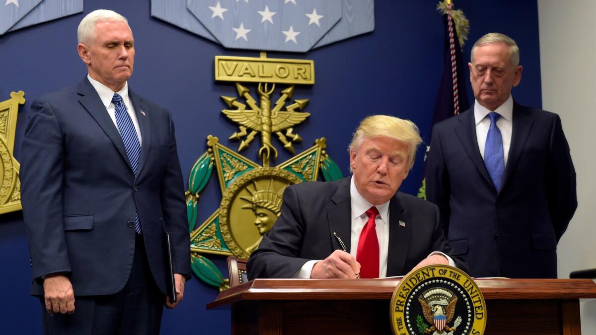 President Trump signs the original travel ban executive order on Jan. 27, 2017. (Susan Walsh / AP)