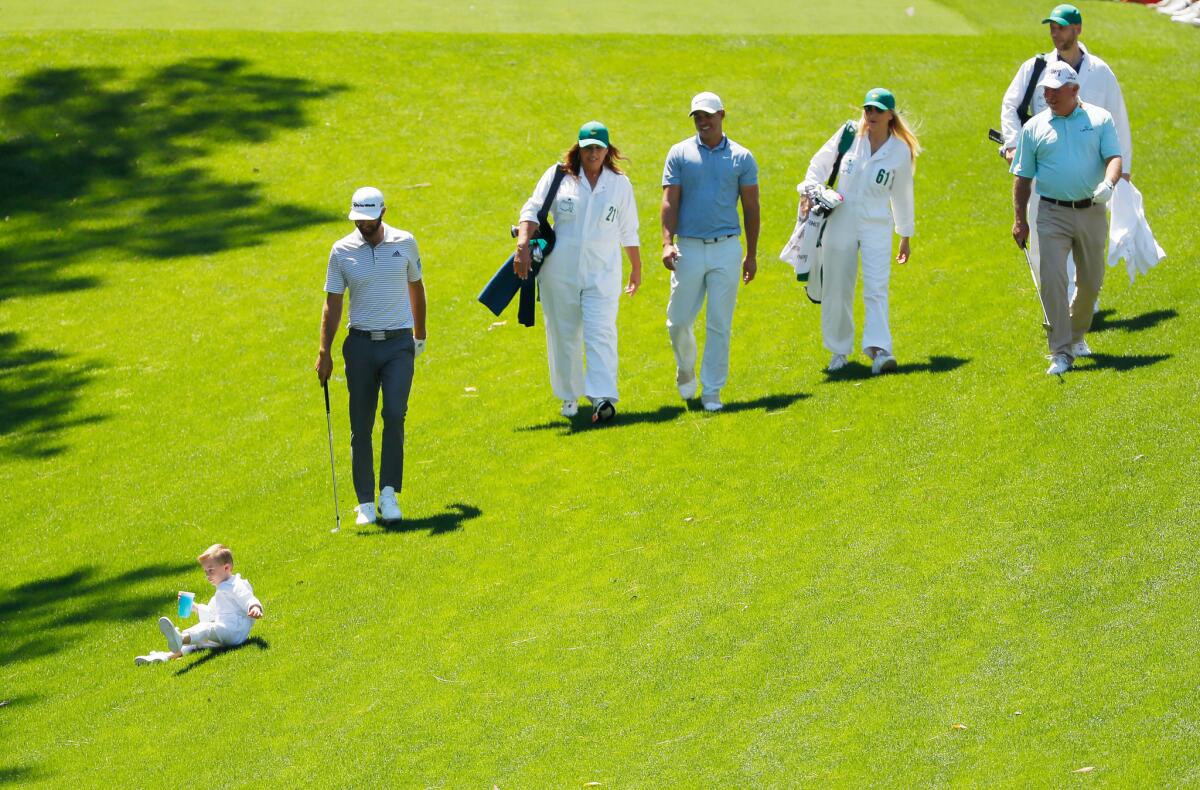 Dustin Johnson, Brooks Koepka and Mark O'Meara walk with various family members during the par-three contest.