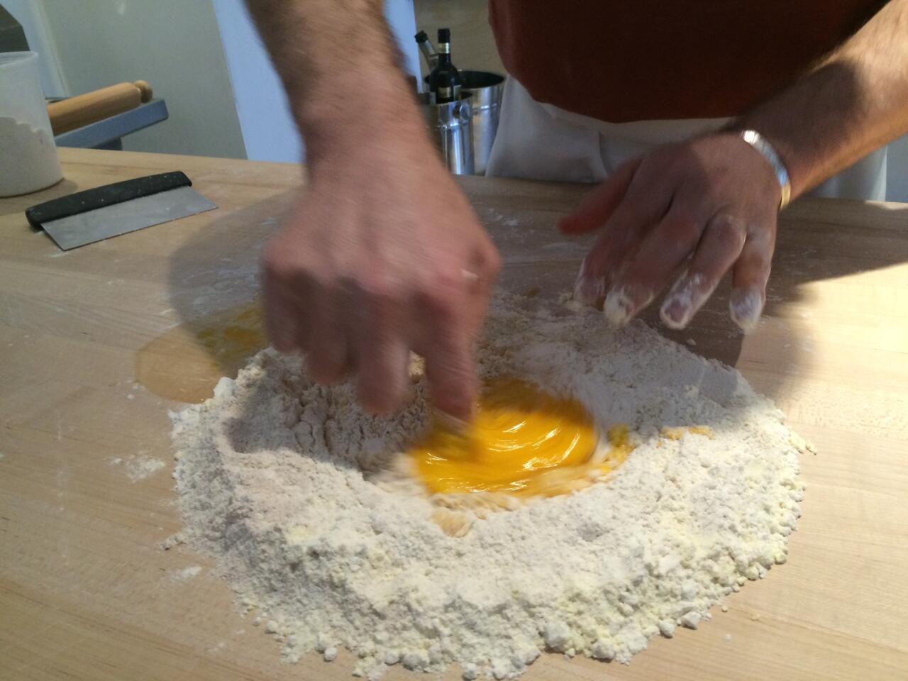 Stirring the eggs into the flour with a finger