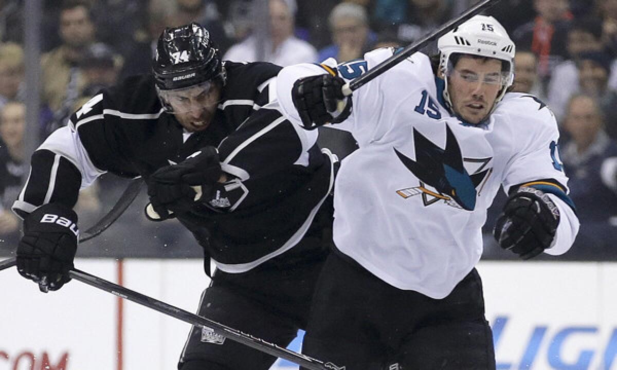 Kings left wing Dwight King, left, delivers a hit on San Jose Sharks left wing James Sheppard during a game on Dec. 19. The Kings renew their playoff rivalry with the Sharks this week.