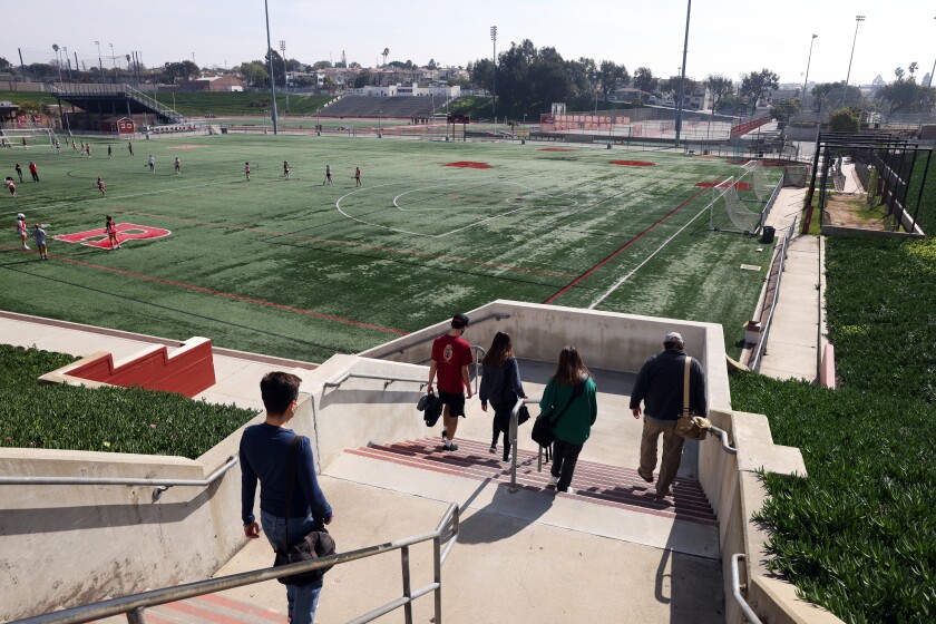 Yearbook adviser Mitch Ziegler, right, leads yearbook photographers to the field to document lacrosse practice in February.