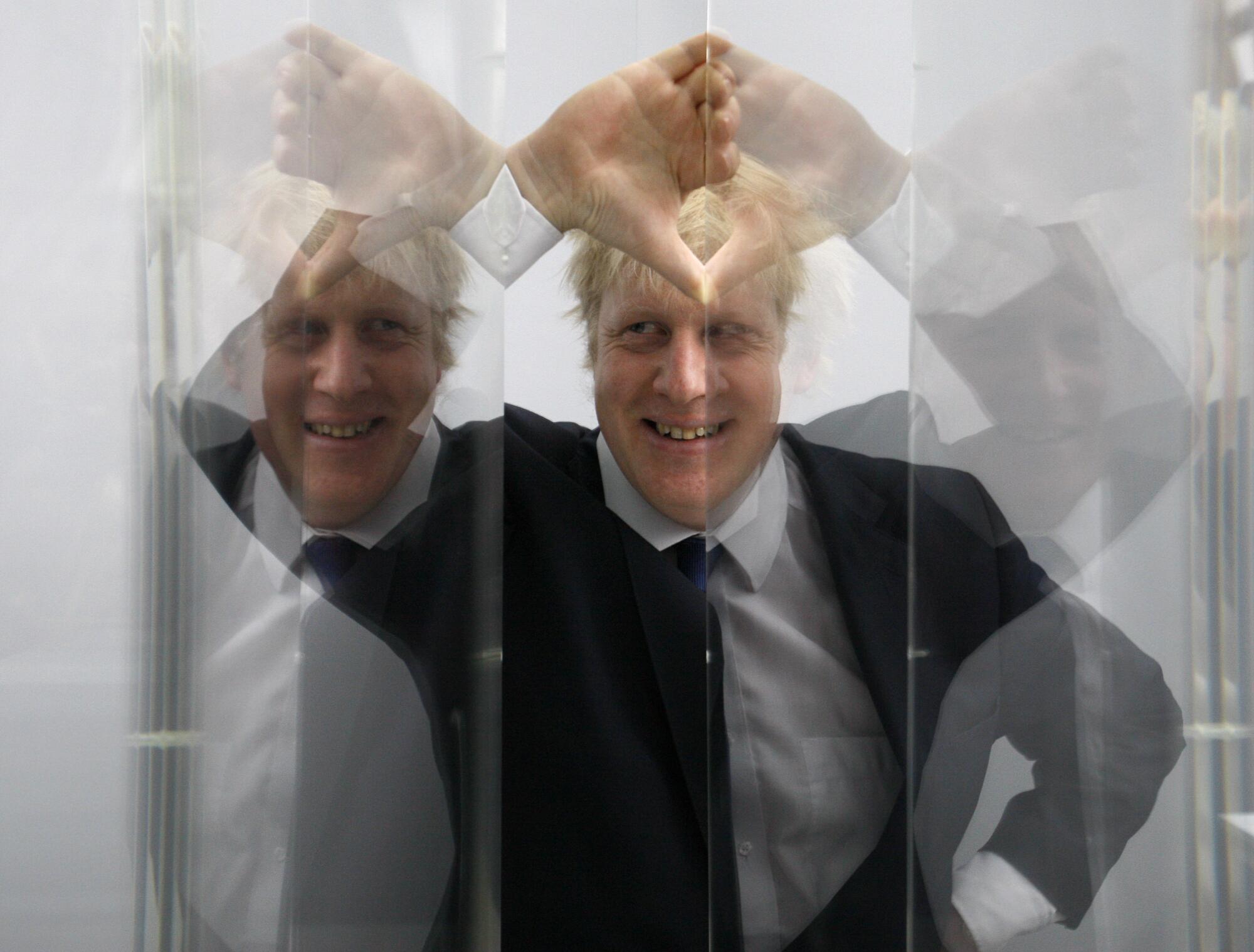 Boris Johnson, then Mayor of London in seen looking through perspex as models of the next two commissions 