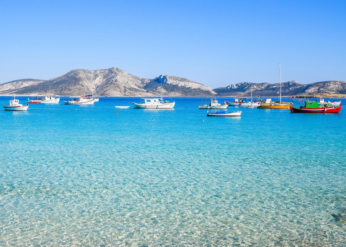 Traditional fishing boats in turquoise waters provide picturesque views at Koufonisia in Small Cyclades, Greece.