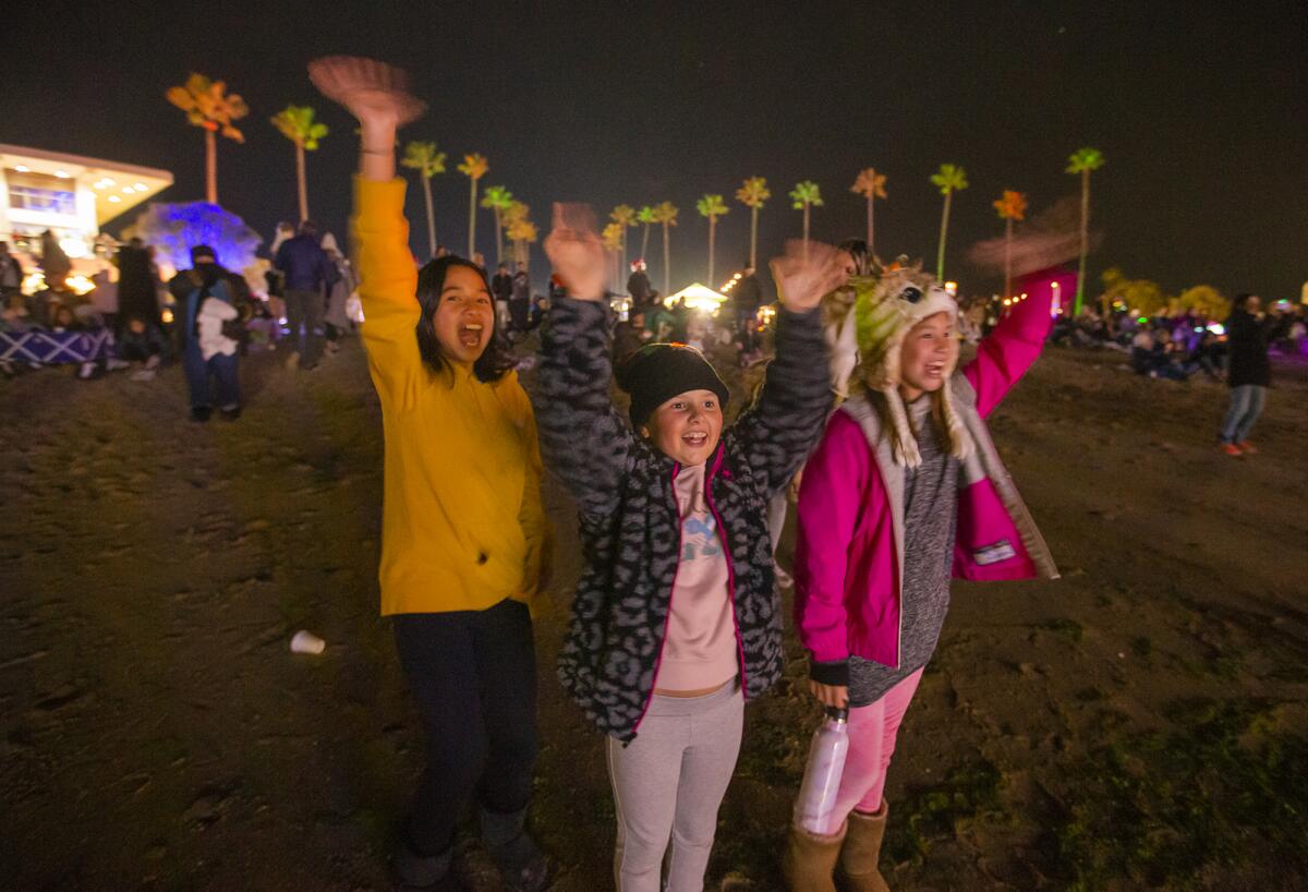 Ricci Del La Pena, 10, left, Ella Ivrahimpasic, 9, and Kady Kintner, 9 wave to Santa.