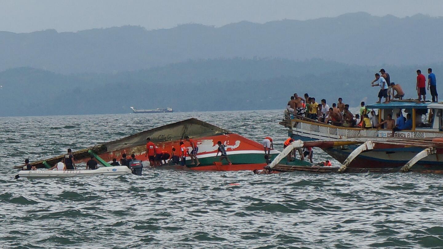 Rescuers help passengers from a capsized ferry off Ormoc city on Leyte Island in the Philippines on July 2.