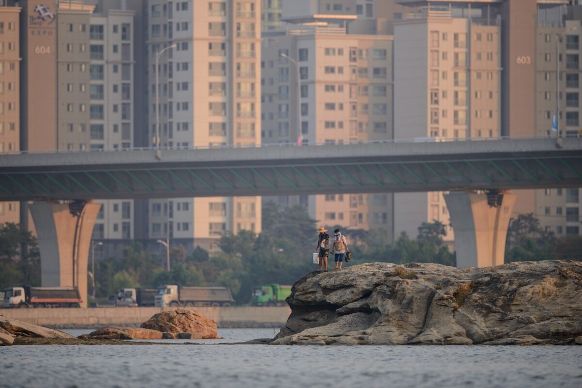 A couple walks along the harbor in Songdo