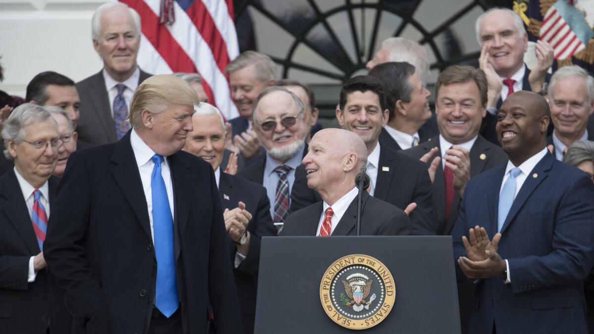 House Ways and Means Committee Chairman Kevin Brady (R-Texas), center, turns to President Trump in December as Republicans celebrated passage of last year's tax cut bill. Brady is pushing follow-up legislation that would make the temporary individual tax cuts permanent.