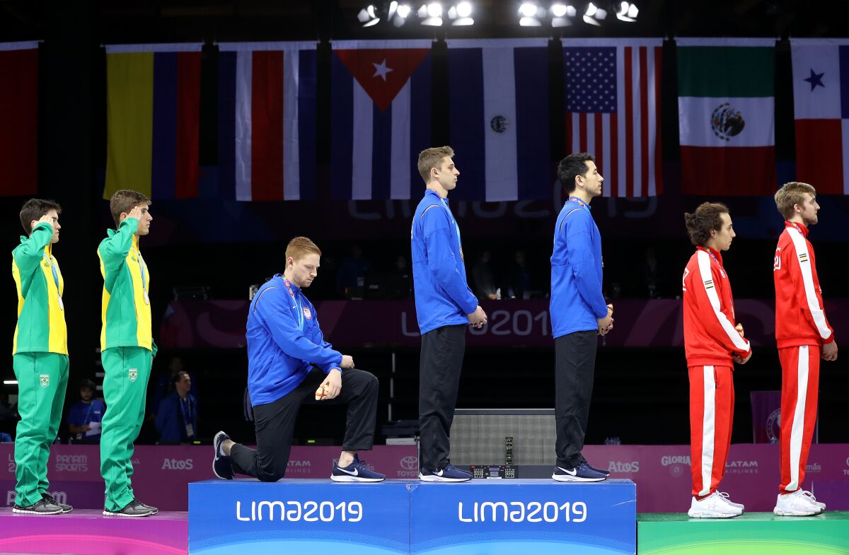 Gold medalist Race Imboden of United States takes a knee 
