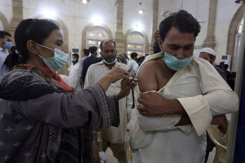 A man receives a shot of the Sinovac COVID-19 vaccine from a health worker, at a vaccination center in Karachi, Pakistan, Monday, Aug. 2, 2021. (AP Photo/Fareed Khan)