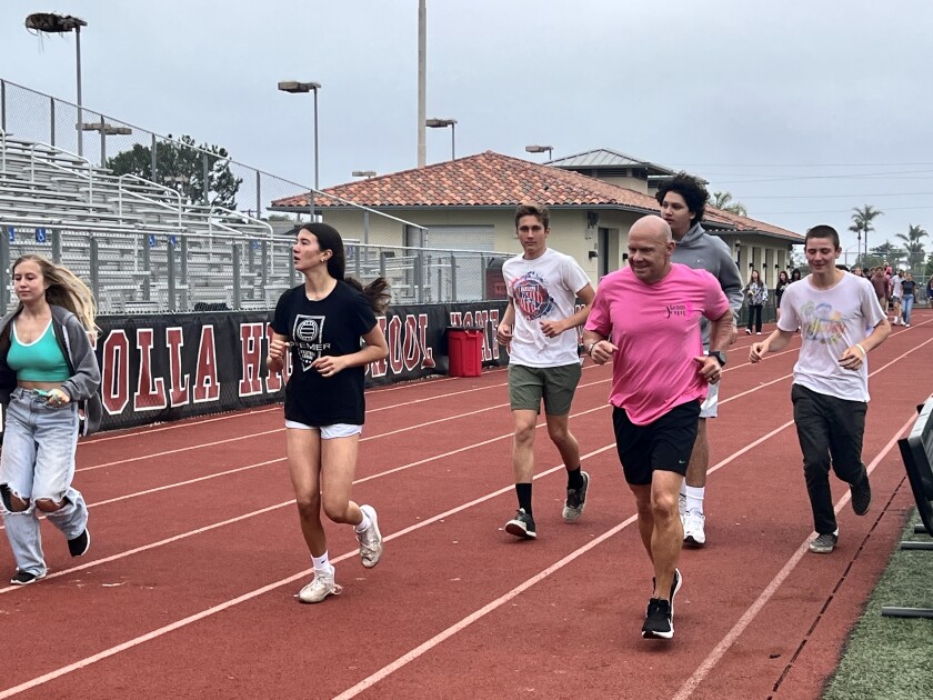 Tom Atwell (in pink shirt) completed 100 miles around the La Jolla High School track June 9 to help fight breast cancer.