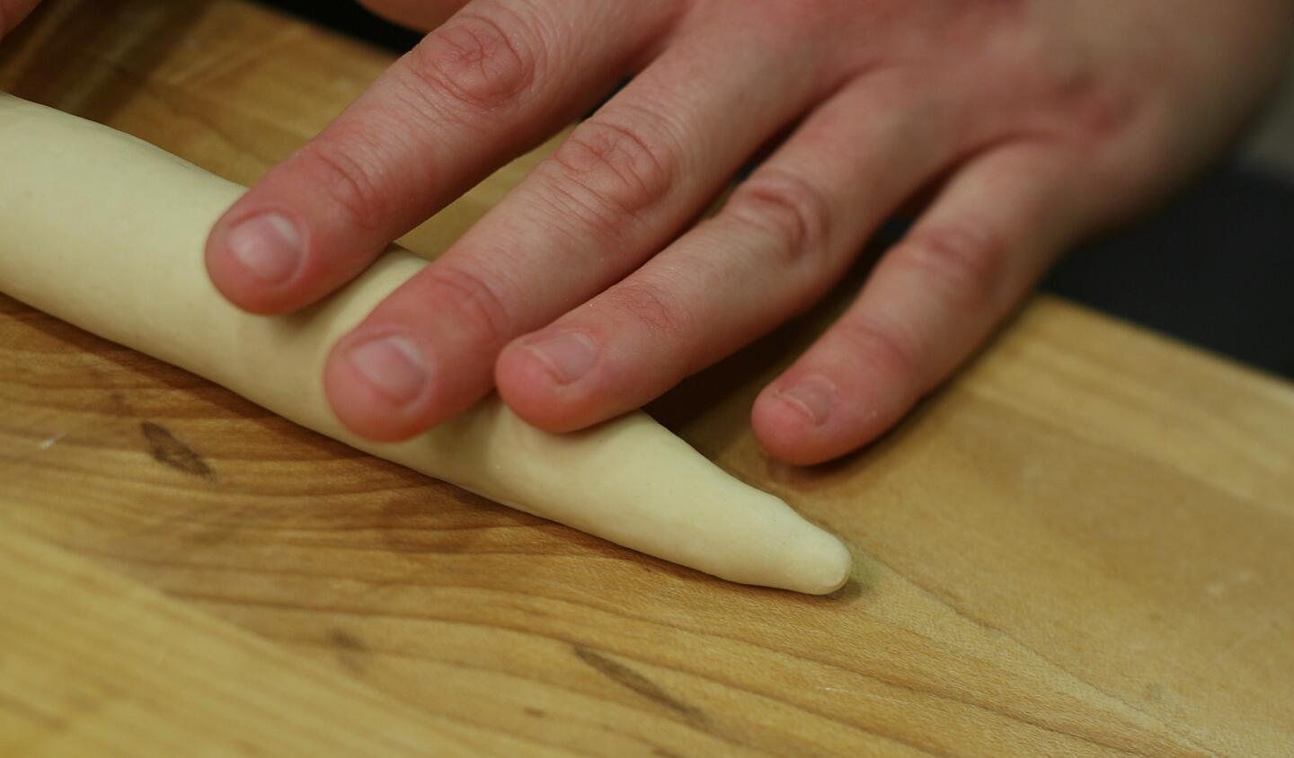 Form each ball of dough into a "rope" 8 to 10 inches long and tapered at the end.