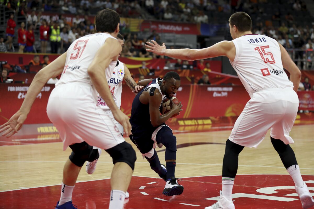 Kemba Walker of the U.S. tries to slip past Serbia's Boban Marjanovic, left and Nikola Jokic during FIBA World Cup play Sept. 12 in Dongguan, China.