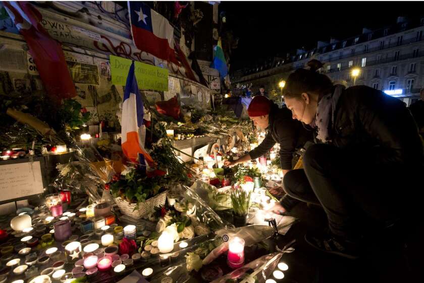 People light candles at a makeshift memorial in tribute to the victims of Paris' attacks' on November 15, 2015 at the place de la Republique in Paris.