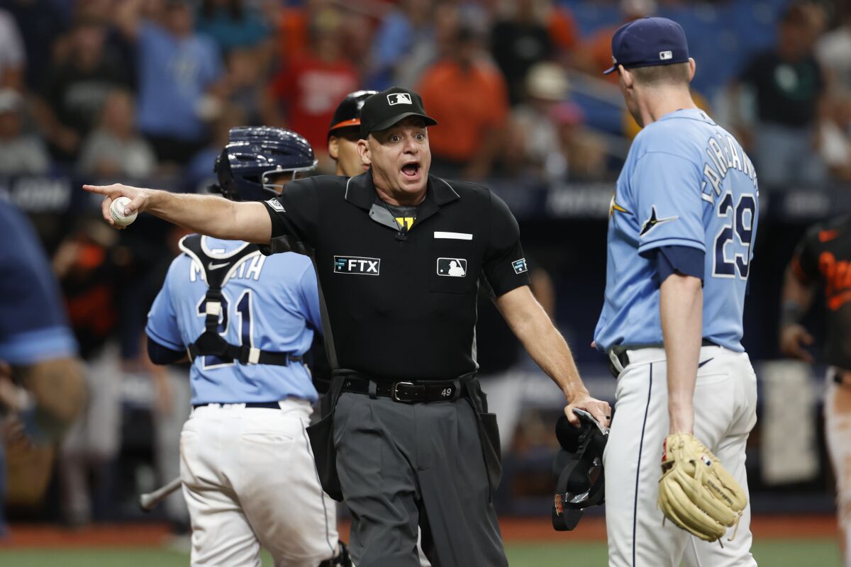 El umpire del plato Andy Fletcher le hace una indicación a Peter Fairbanks, lanzador de los Rays de Tampa Bay, durante un altercado en el juego ante los Orioles de Baltimore, el sábado 13 de agosto de 2022 (AP Foto/Scott Audette)