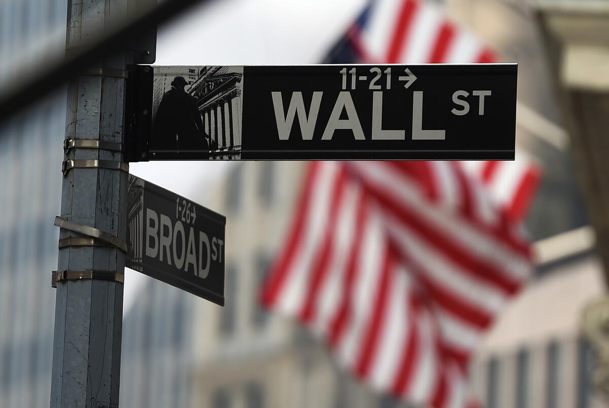 A Wall Street sign is next to a sign that says Broad Street.