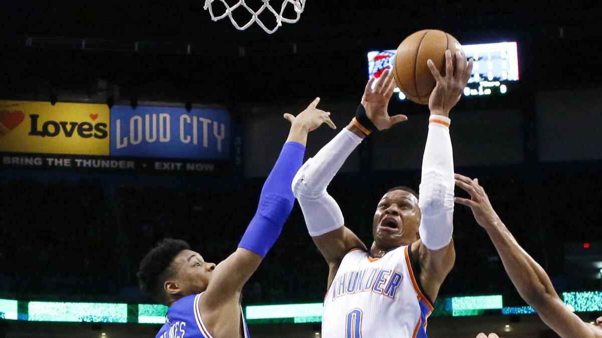 Thunder guard Russell Westbrook (0) tries to power his way to the basket against 76ers forward Richaun Holmes (22) during the first quarter Wednesday night in Oklahoma City.