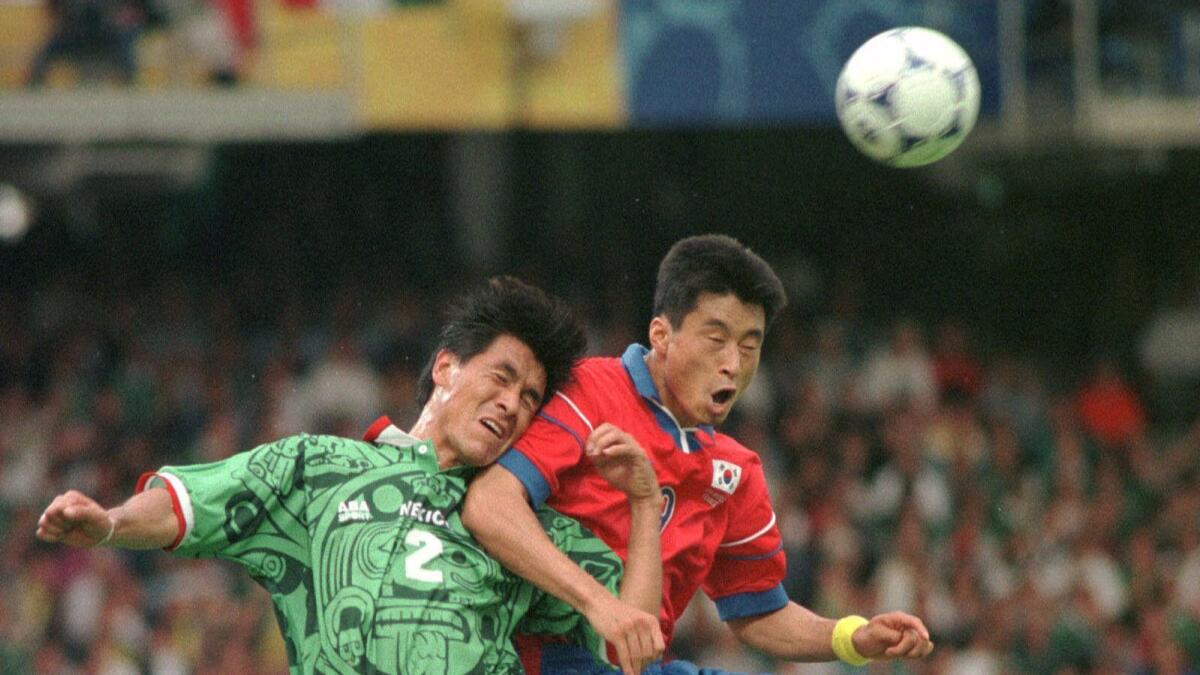 Mexico's Claudio Suarez, left, battles for the ball with South Korea's Kim Do Hon during the South Korea vs. Mexico, Group E, World Cup 98, soccer match at Gerland stadium in Lyon, Saturday, June 13 1998. Mexico defeated South Korea 3-1.