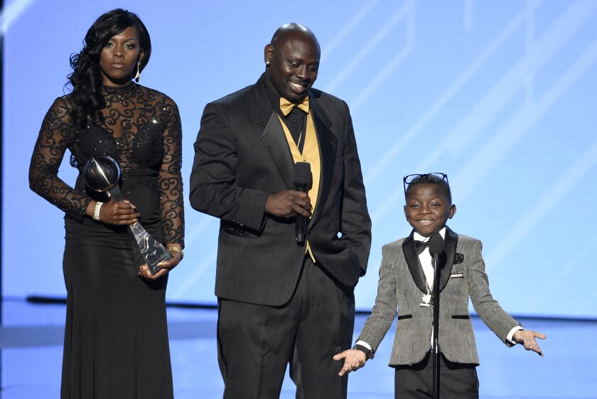 FILE - In this Wednesday, July 12, 2017, file photo, New Orleans Saints super fan Jarrius "J.J." Robertson, right, accepts the Jimmy V perseverance award with his parents, from left, Patricia Hoyal and Jordy Robertson at the ESPYS at the Microsoft Theater on in Los Angeles. Jordy Robertson, whose seriously ill son Jarrius gained fame in New Orleans for his devotion to the Saints football team, was sentenced to eight years in prison Tuesday, May 11, 2021, for drug trafficking and for fraudulently capitalizing on his son's illness with a phony charity. (Photo by Chris Pizzello/Invision/AP, File)