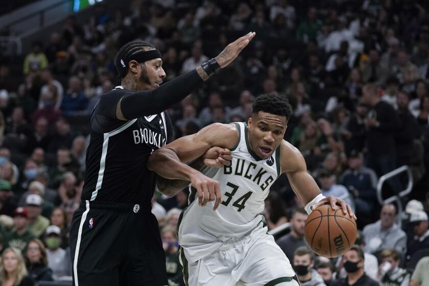 Milwaukee Bucks' Giannis Antetokounmpo (34) is defended by Brooklyn Nets' James Johnson during the first half of an NBA basketball game Tuesday, Oct. 19, 2021, in Milwaukee. (AP Photo/Morry Gash)