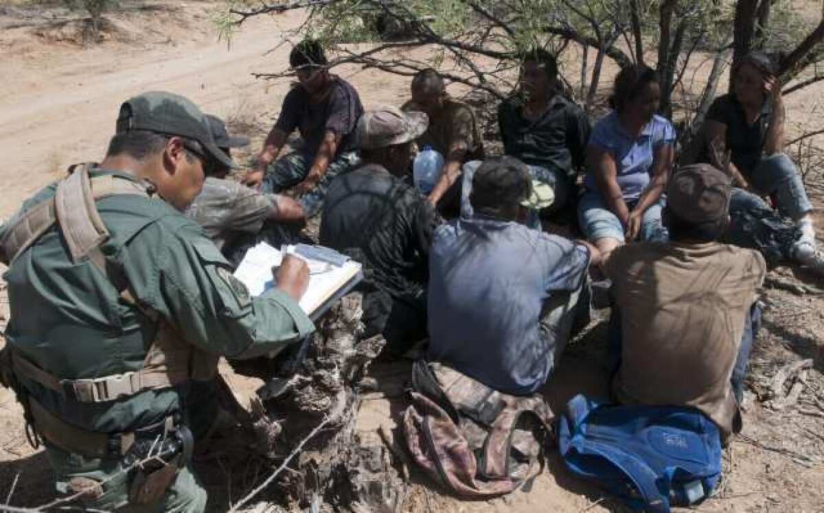 Un miembro del equipo de rescate de la Patrulla Fronteriza, junto a indocumentados arrestados en Arizona.