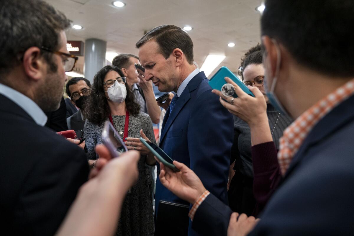 People holding up cellphones surround a man.