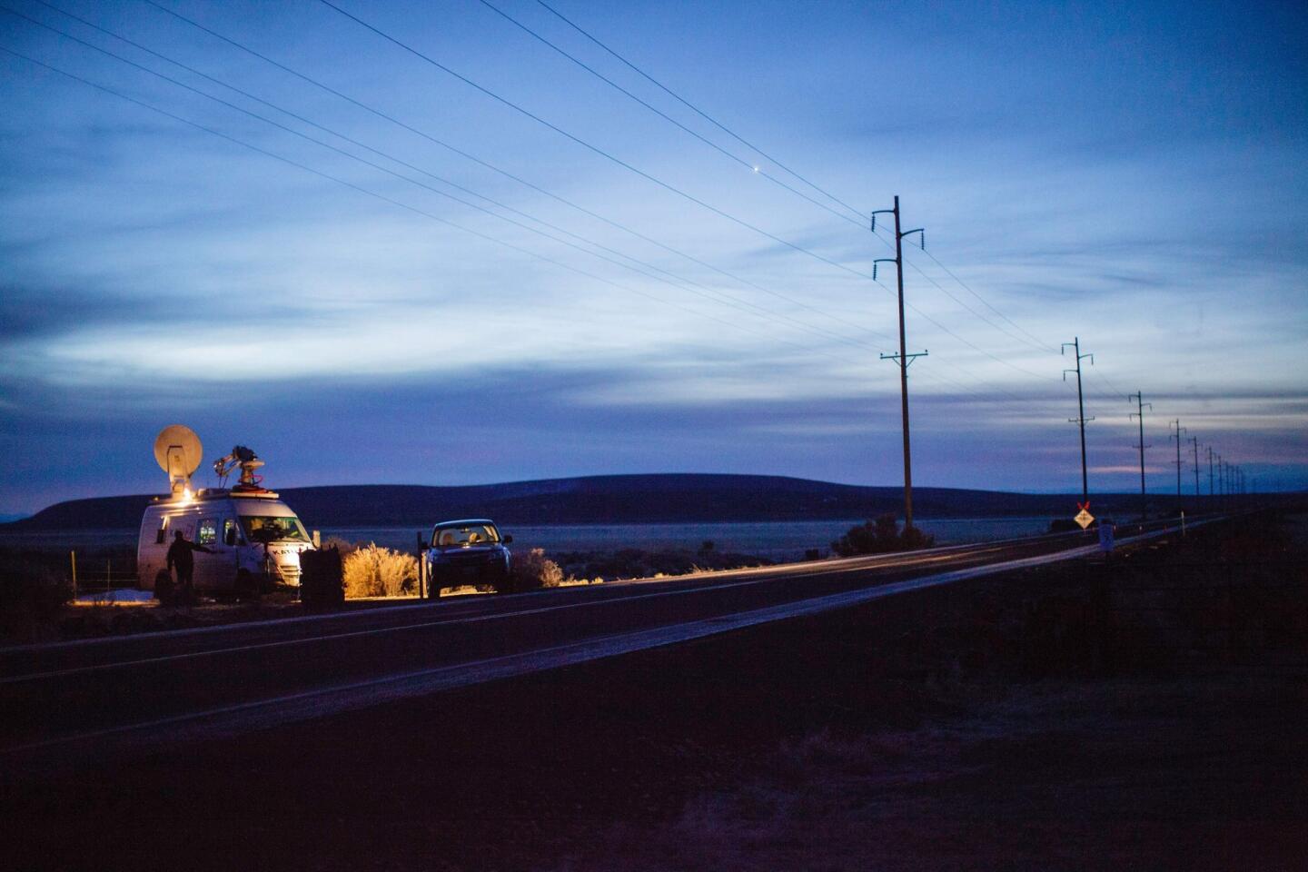A television truck and a reporter in a car sit along Highway 78 near Malheur National Wildlife Refuge in Oregon on Jan. 27.