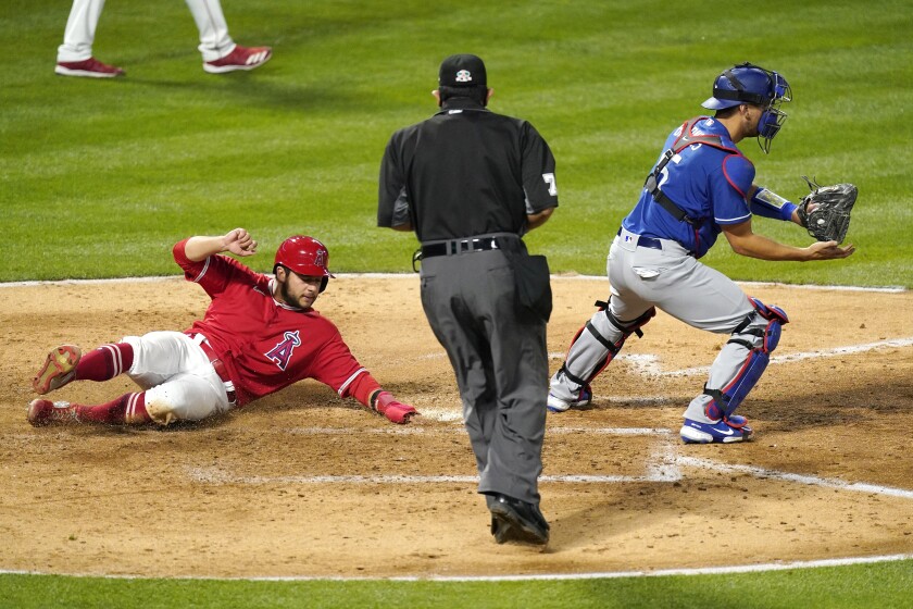 Los Angeles Angels' David Fletcher, left, scores on a single by Mike Trout as Los Angeles Dodgers catcher Austin Barnes takes a late throw during the fourth inning of a spring training exhibition baseball game Sunday, March 28, 2021, in Anaheim, Calif. (AP Photo/Mark J. Terrill)