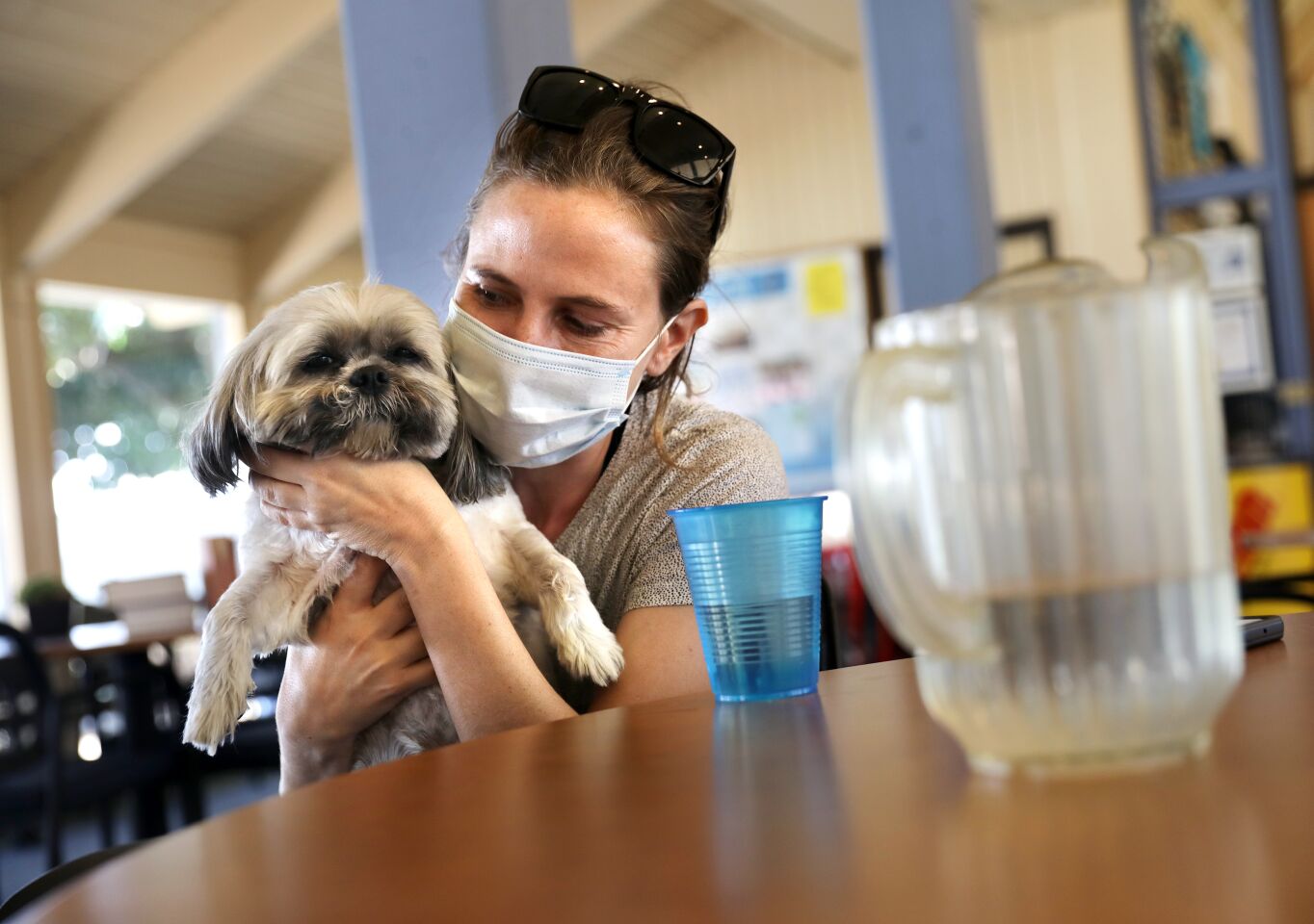 Charlotte Henderson and her dog Benny find relief from the heat at a cooling center in Seal Beach.
