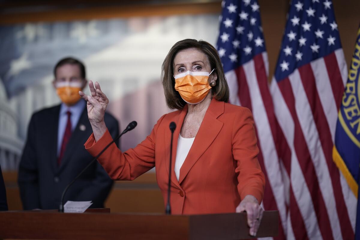 House Speaker Nancy Pelosi at a lectern 