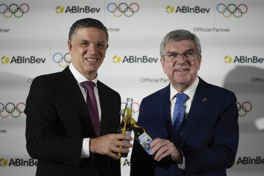El director ejecutivo de Anheuser-Busch InBev Michel Doukeris y el presidente del IOC Thomas Bach en conferencia de prensa en Londres para presentar el nuevo patrocinador el viernes 12 de enero del 2024. (AP Foto/Kin Cheung)