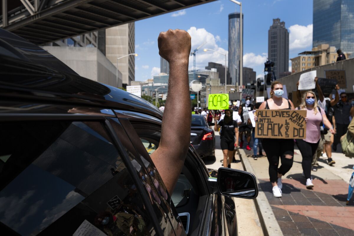Passengers in cars show support for protesters marching in Atlanta on Saturday.