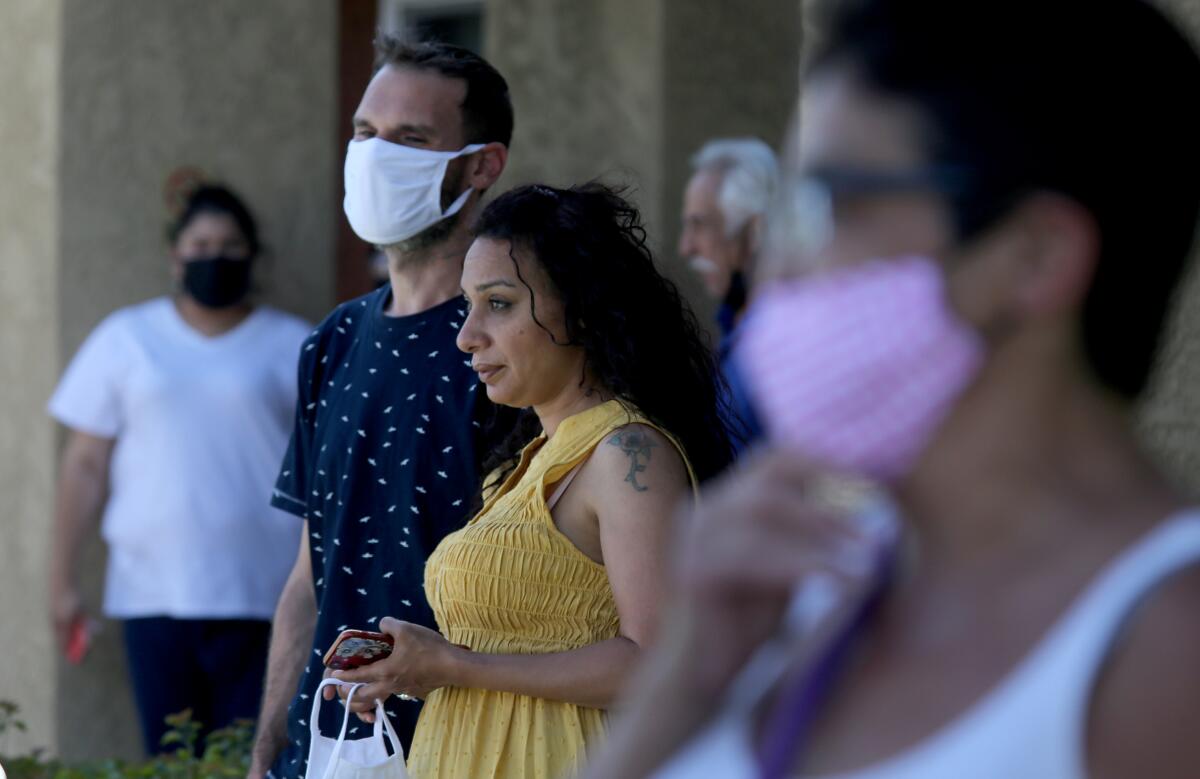 Neighbors look on outside the Reseda apartment.