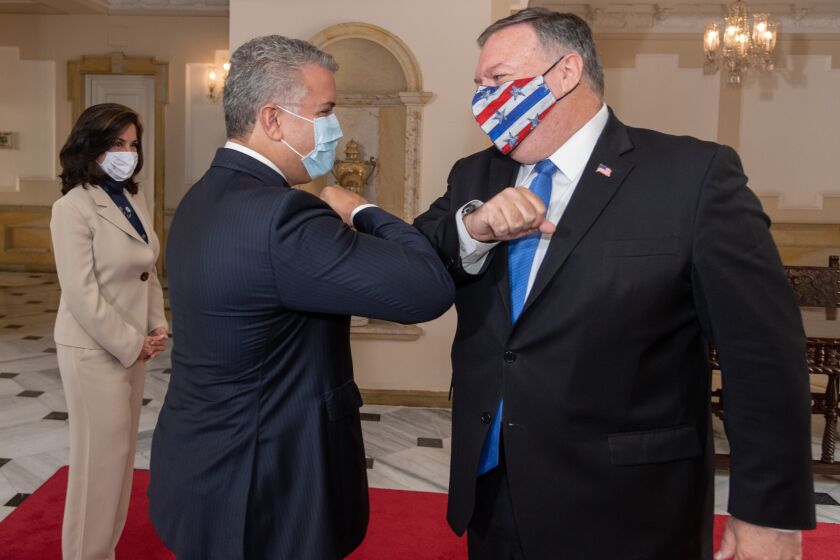 In this handout photo released by Colombia's Presidential Press Office, Colombian President Ivan Duque and U.S. Secretary of State Mike Pompeo bump elbows before their meeting at the presidential house in Bogota, Colombia, Saturday, Sept. 19, 2020. Pompeo on Saturday wrapped up a tour of four South American countries — three of them neighbors of Venezuela, whose socialist government is under intense U.S. pressure. (Nicolas Galeano/Colombia's Presidential Press Office via AP)