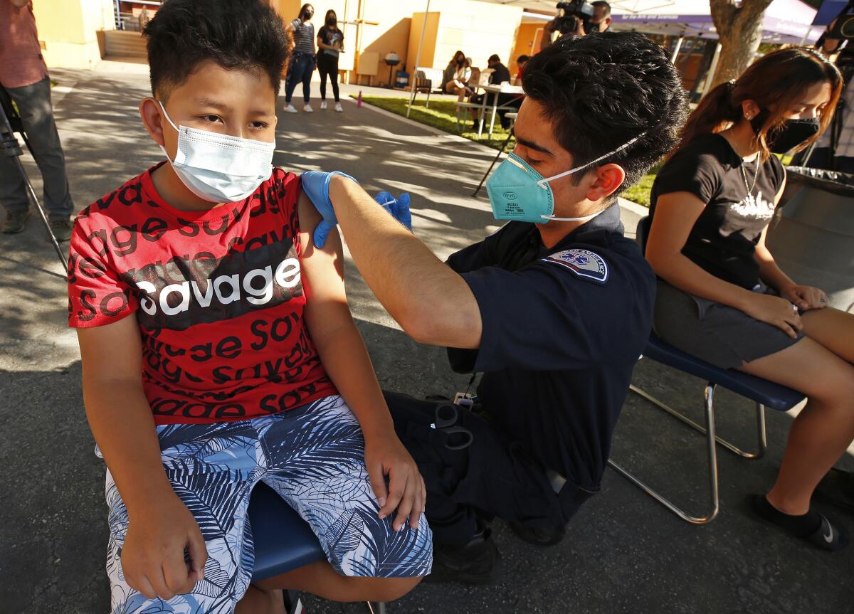 A boy gets a vaccination from an EMT