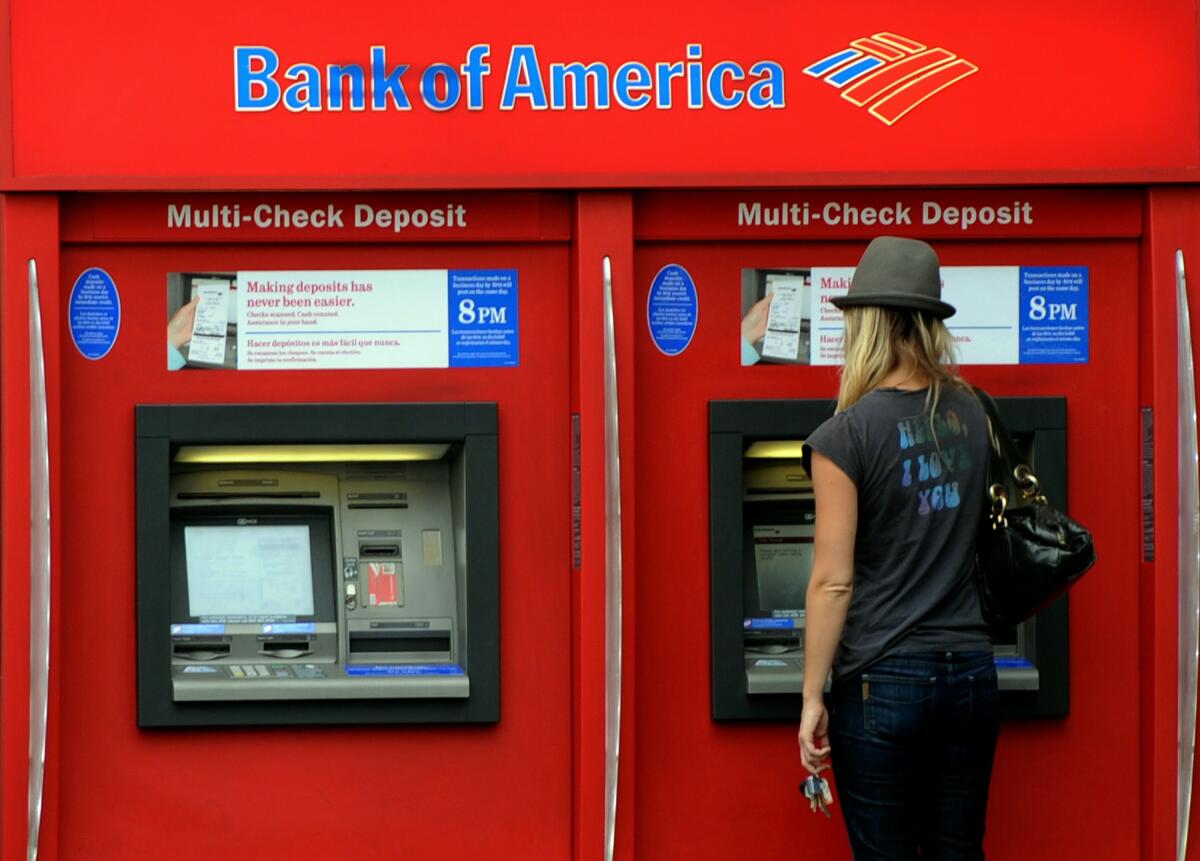 A woman uses a red ATM. 