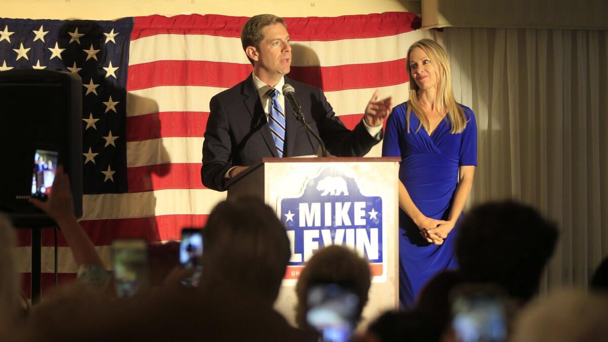 Mike Levin, congressional candidate for the 49th District, with his wife, Chrissy, speaks to supporters on election night. The Democrat won a spot in the general election contest to replace GOP Rep. Darrell Issa.