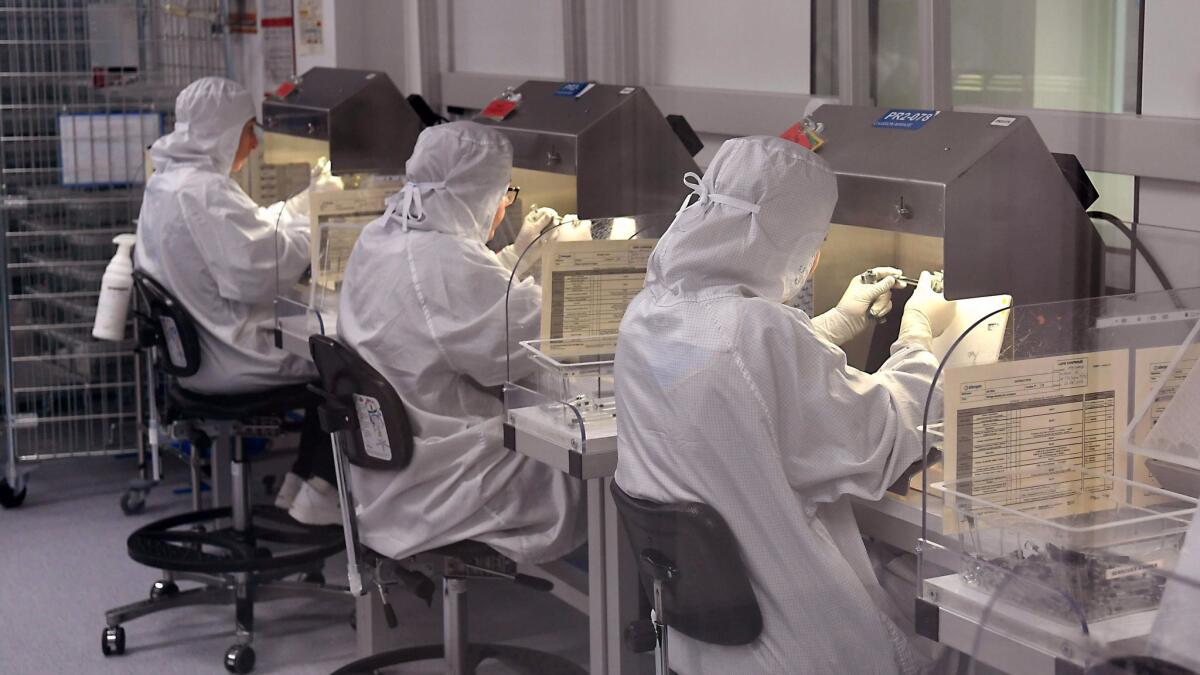 Lab workers examine samples at an Allergan research site in France. A U.S. judge has cast doubt on the company's scheme to protect its drug patents by trading them to a New York Indian tribe.