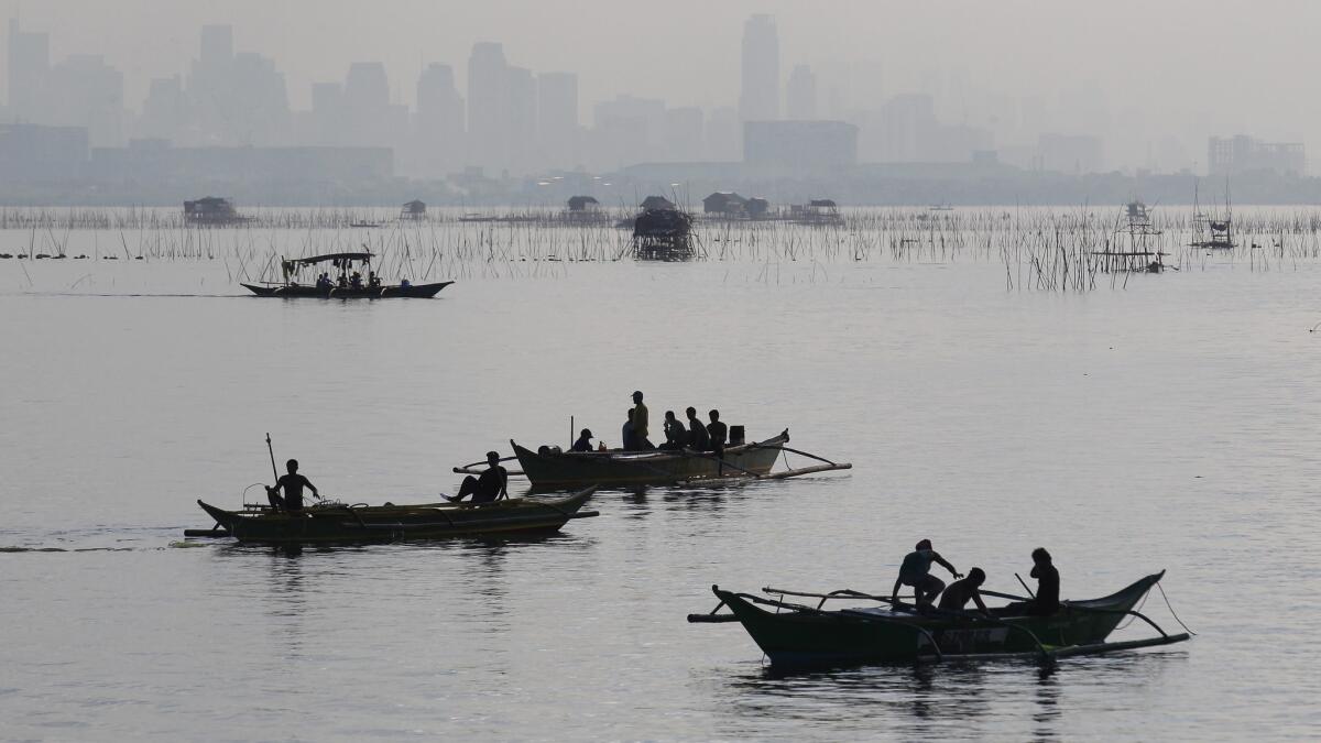 Filipino fishermen catch fish in the city of Las Piñas, about 15 miles south of Manila. Philippine Airlines is offering a $610 round trip to the island nation.