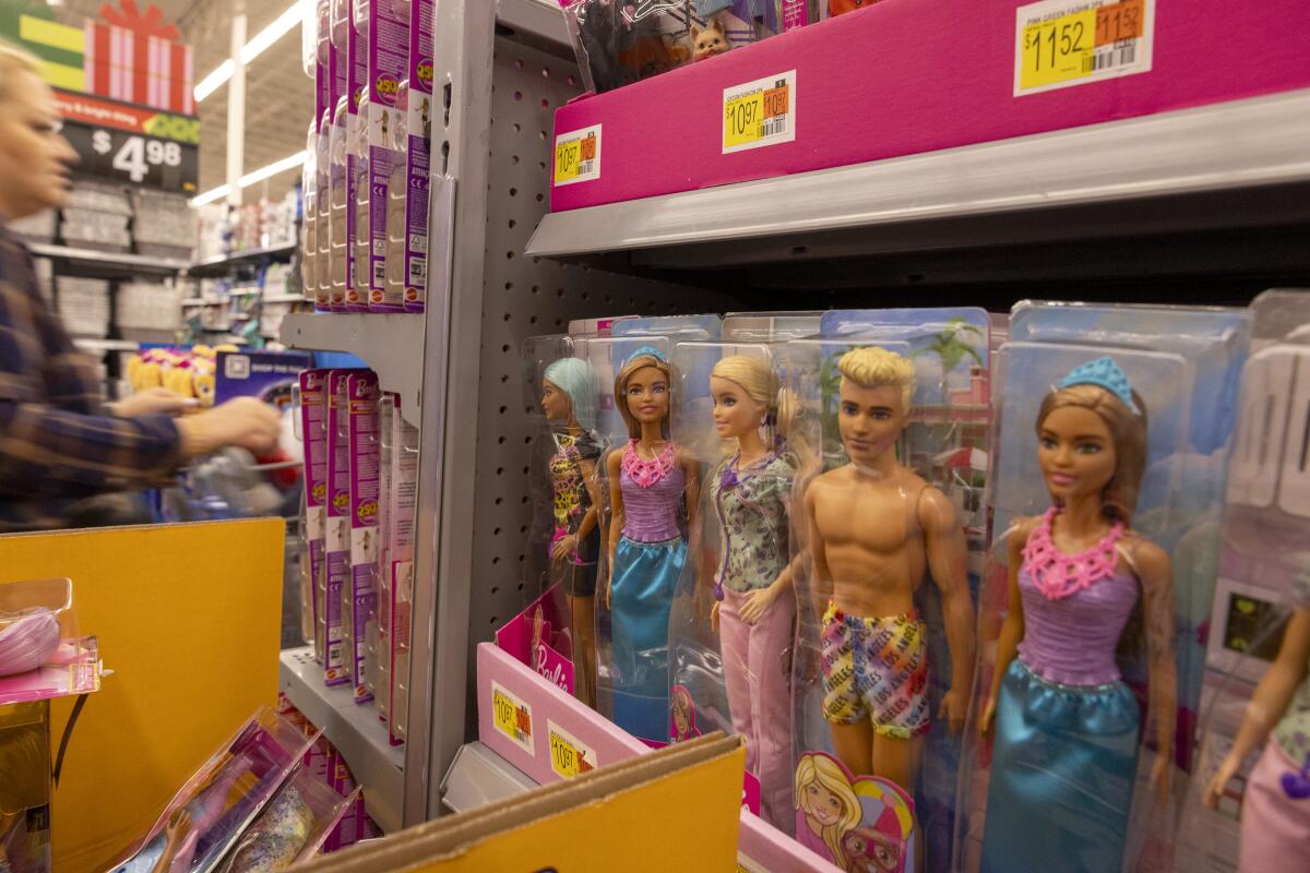 Mattel toys including Ken and Barbie dolls are on a store shelf.