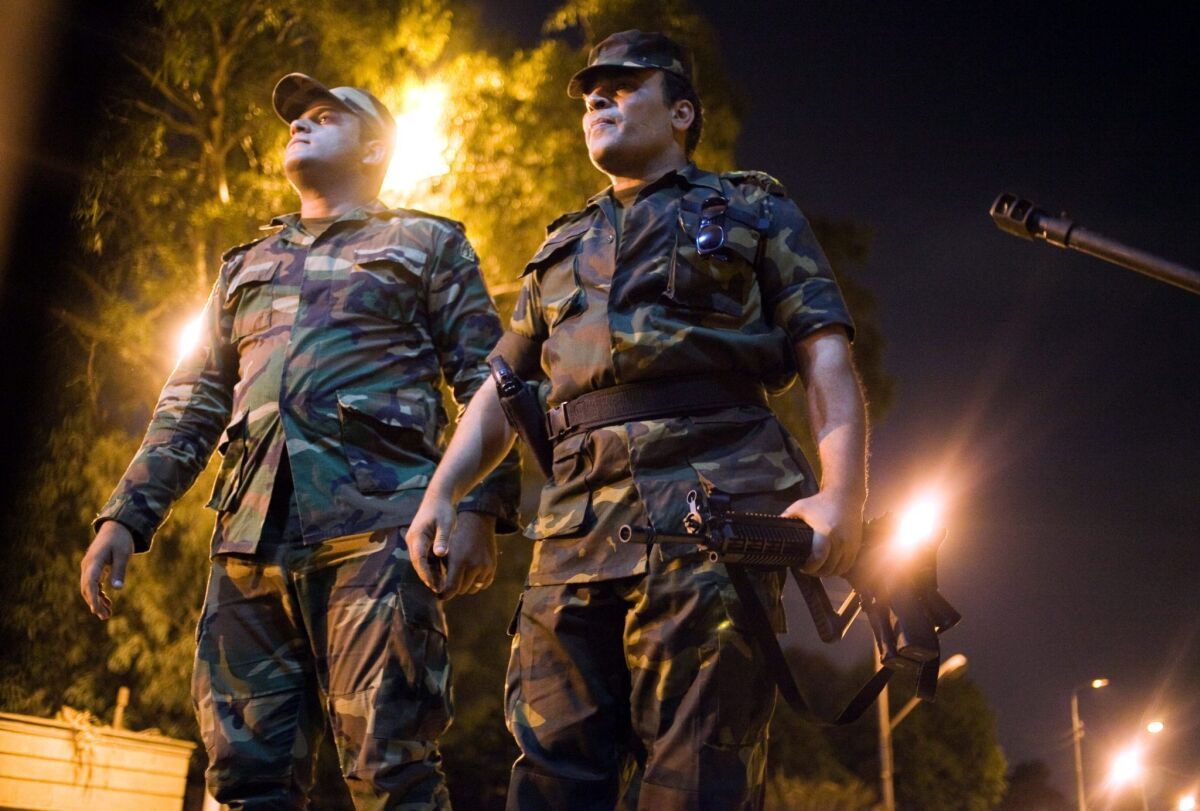 Egyptian army officers look on as as opponents of ousted President Mohamed Morsi celebrate.
