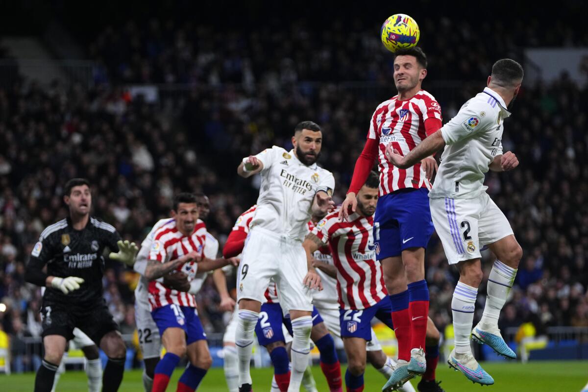 Saul del Atlético de Madrid cabecea el balón frente a Dani Carvajal del Real Madrid 