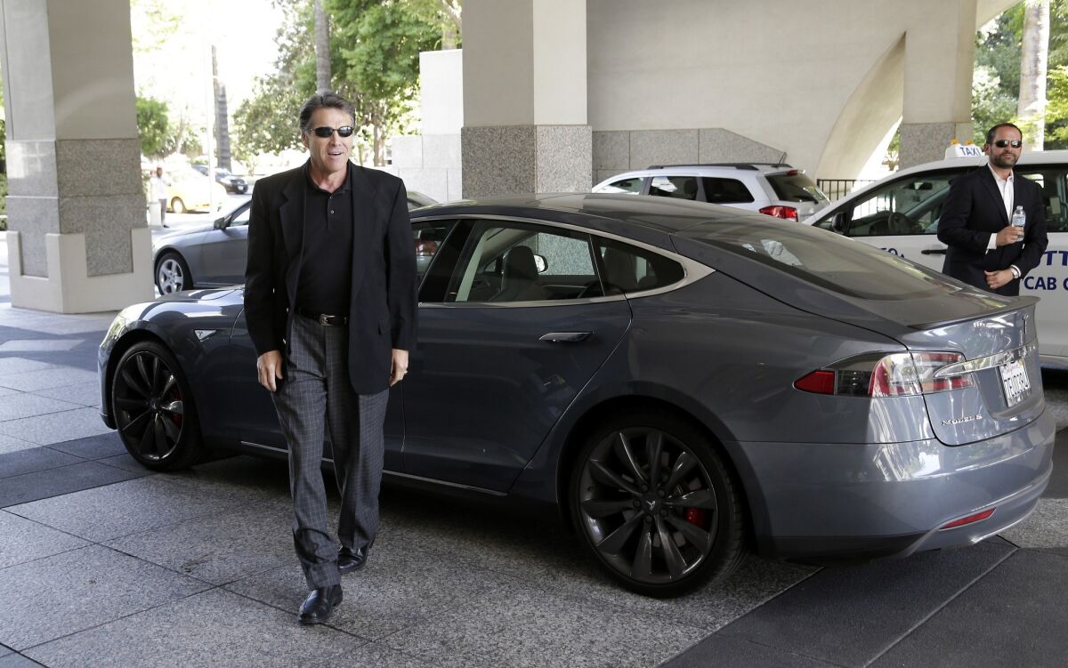 Then-Texas Gov. Rick Perry arrives in a Tesla Motors Type S electric car for a meeting with state lawmakers in Sacramento in 2014.
